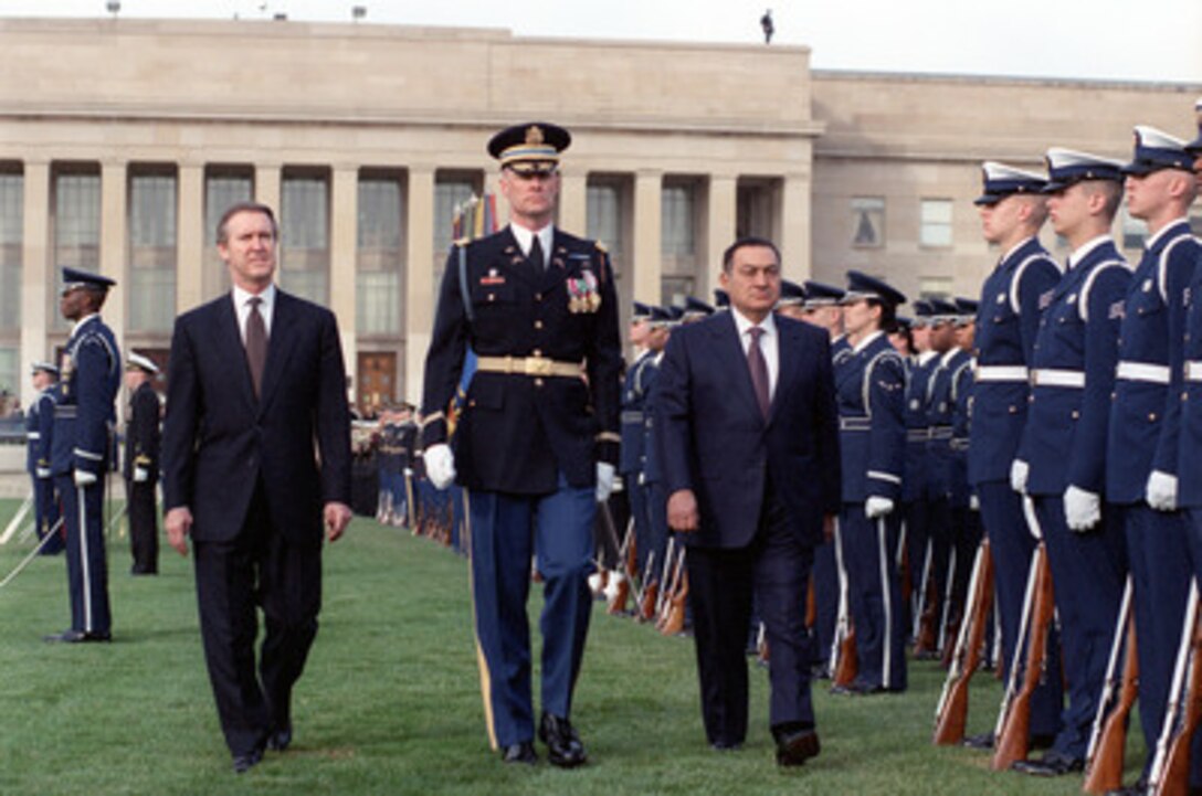 Secretary of Defense William S. Cohen (left) joins Lt. Col. Charles Sniffin (center), U.S. Army, the commander of troops, in escorting visiting Egyptian President Hosni Mubarak (right) as he inspects the joint services honor guard during a March 30, 2000, ceremony welcoming him to the Pentagon. Following the full honors arrival ceremony, Mubarak participated in a working breakfast attended by not only senior Department of Defense officials, but also several prominent U.S. senators. 