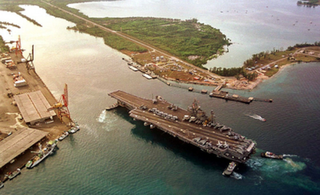 Sailors aboard the USS Kitty Hawk (CV 63) man the rails as the aircraft carrier pulls into Apra Harbor, Guam, on April 17, 2000, for a three-day port visit. 