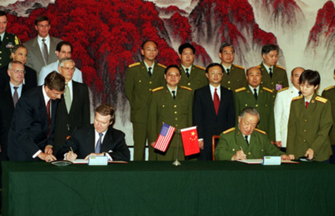 Secretary of Defense William S. Cohen (seated left) and Minister of National Defense Gen. Chi Haotian (seated right) sign an Environmental Memorandum of Understanding at the Ministry of National Defense in Beijing, China, on July 12, 2000. Cohen is visiting Beijing, Shanghai and Sydney, Australia as part of a seven day trip to the Western Pacific. 
