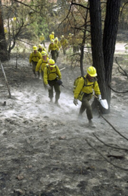 Infantrymen with the Montana Army National Guard trudge up a fire-scarred hill in Montana's Helena National Forest on Aug. 3, 2000, after wildfires ravaged the area east of the state's capital. Over 400 Montana National Guard men and women are currently on state-active duty helping fight wildfires in the worst fire season since 1988. These citizen-soldiers are attached to Company B, 1st Battalion, 163rd Mechanized Infantry, Boseman, Montana. 