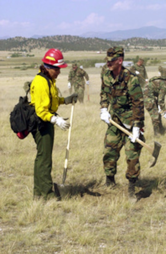 Montana Army National Guard Spc. Wayne Hard (right) listens to the instructions of fire fighting instructor Andrea Gilham while she explains the construction of a fire break during training at Fort Harrison near Helena, Mont. on Aug. 3, 2000. Montana Army and Air National Guard troops are receiving two days of fire fighting and safety training to prepare them to tackle raging wild fires throughout their state. Over 400 Montana National Guard men and women are currently on state-active duty helping fight wildfires in the worst fire season since 1988. Hard is a medic with the Headquarters and Headquarters Company, 1st Battalion, 163rd Mechanized Infantry, Boseman, Montana. Browning is a forester with the U.S. Department of Indian Affairs, Blackfeet Agency. 