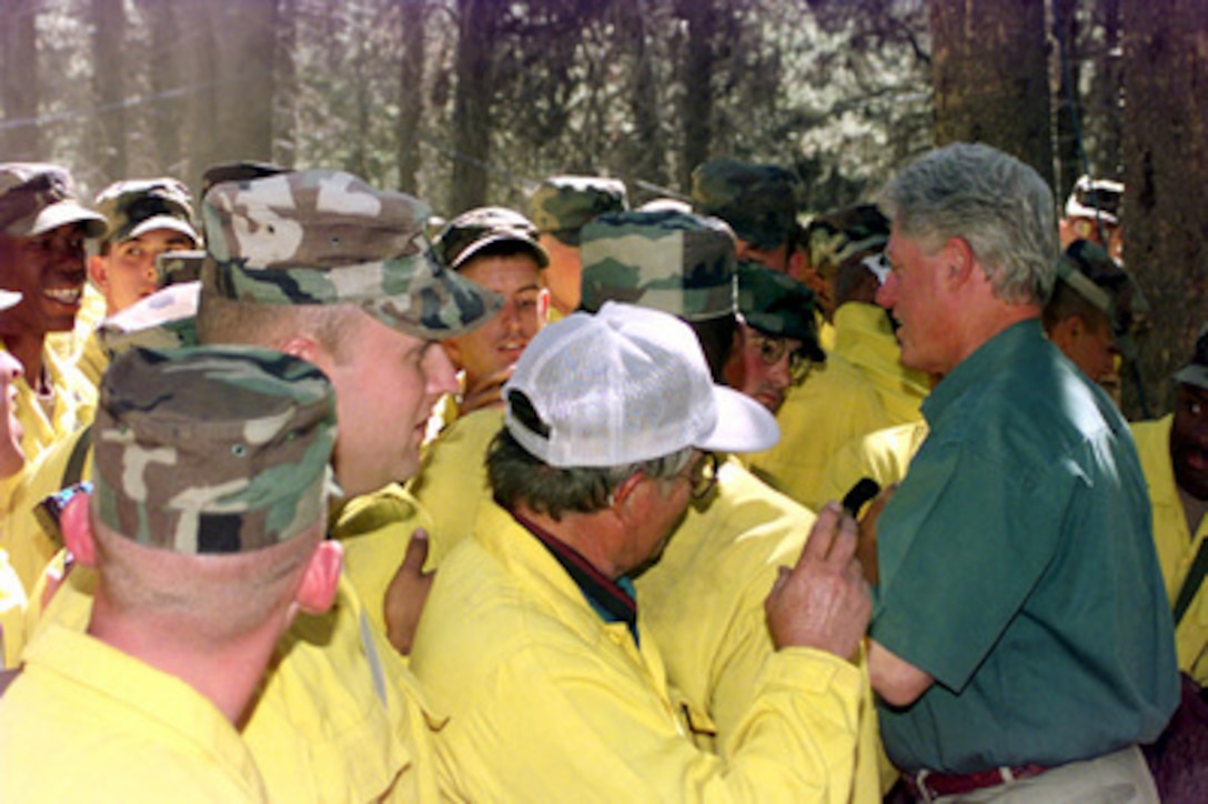 President Bill Clinton shakes hands and talks with soldiers from the Army's 3rd Battalion, 16th Field Artillery Regiment who are on fire fighting duty near Burgdorf Junction, Idaho, on Aug. 8, 2000. More than 2,300 servicemembers from the Army, Marines, Air and Army Guard and Air Force Reserve are conducting firefighting and support operations for the Western wildfires in response to requests from the National Interagency Firefighting Center in Boise, Idaho, and as directed by the governors of several states. 