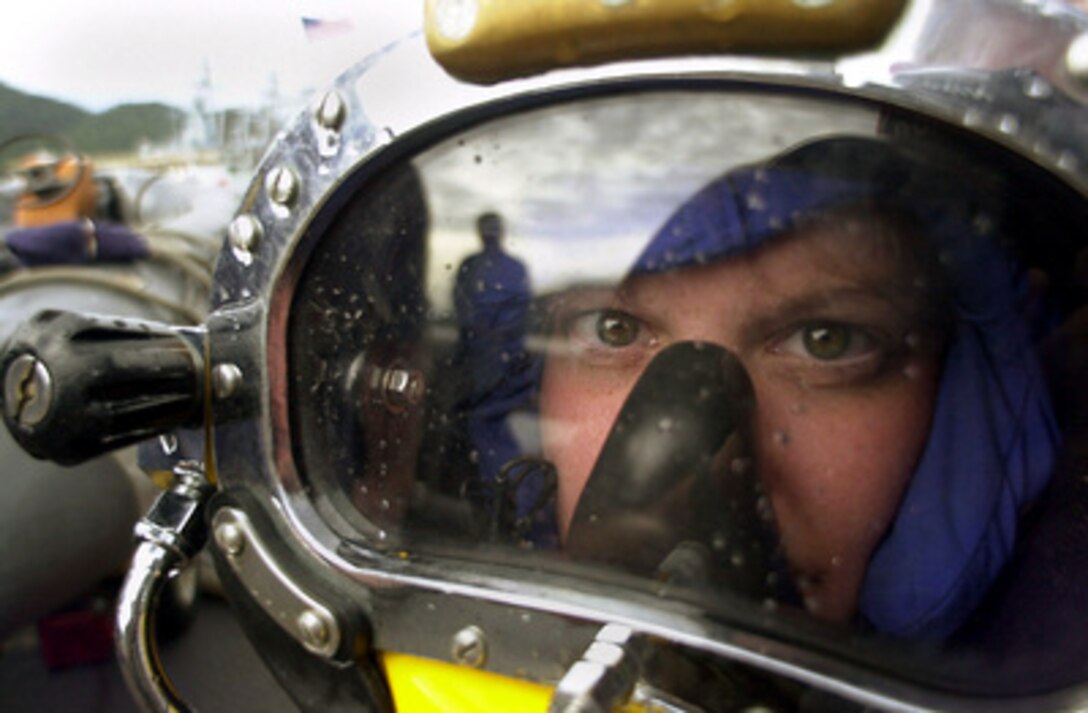 Navy Diver Lt. j.g. Rebecca Aten peers out through a MK-21 dive helmet before entering the ocean in Lumut, Malaysia, from the deck of the USS Safeguard (ARS 50), on Aug. 16, 2000. Aten is in Malaysia for Cooperation Afloat Readiness and Training 2000, an annual series of bilateral exercises between the U.S. and Southeast Asian navies designed to promote interoperability. The Safeguard, which is a rescue and salvage ship, hosted a group of Malaysian deep-sea divers for a familiarization dive with the MK-21 dive system. Aten, from Arlington, Va., is the supply officer aboard the Safeguard. 