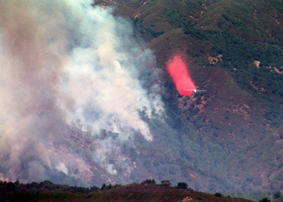 An Air National Guard C-130 Hercules from the 146th Airlift Wing streams a red plume of Phoschek fire retardant alongside the Plaskett II fire south of Big Sur, Calif., on July 27, 2000. The 146th is one of four Air National Guard and Air Force Reserve units utilizing the Modular Airborne Fire Fighting System to fight numerous forest fires burning in the Western United States. More than 2,300 service members from the Army, Marines, Air and Army Guard and Air Force Reserve are conducting fire fighting and support operations for the Western wildfires in response to requests from the National Interagency Firefighting Center in Boise, Idaho, and as directed by the governors of several states. 