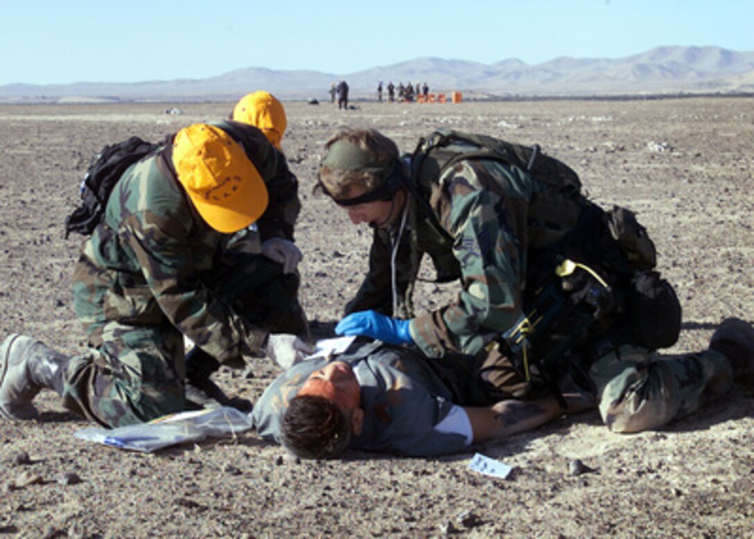 A pararescueman (right) from the California Air National Guard's 129th Rescue Wing and two members of the Chilean Air Force treat a role-playing survivor of a simulated crash in the Atacama Desert north of Santiago, Chile, on Nov. 15, 2000. The mass casualty evacuation exercise was part of a medical and pre-trauma hospital response training exchange between the Chilean Air Force, California Air National Guard and the Wilford Hall Medical Center of Lackland Air Force Base, Texas. 