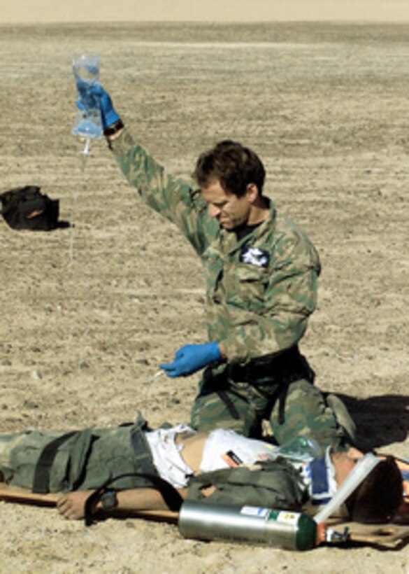 Senior Master Sgt. Tim Young, of the 129th Air Rescue Wing, treats a role-playing survivor of a simulated crash in the Atacama Desert north of Santiago, Chile, on Nov. 15, 2000. The mass casualty evacuation exercise was part of a medical and pre-trauma hospital response training exchange between the Chilean Air Force, California Air National Guard and the Wilford Hall Medical Center of Lackland Air Force Base, Texas. 