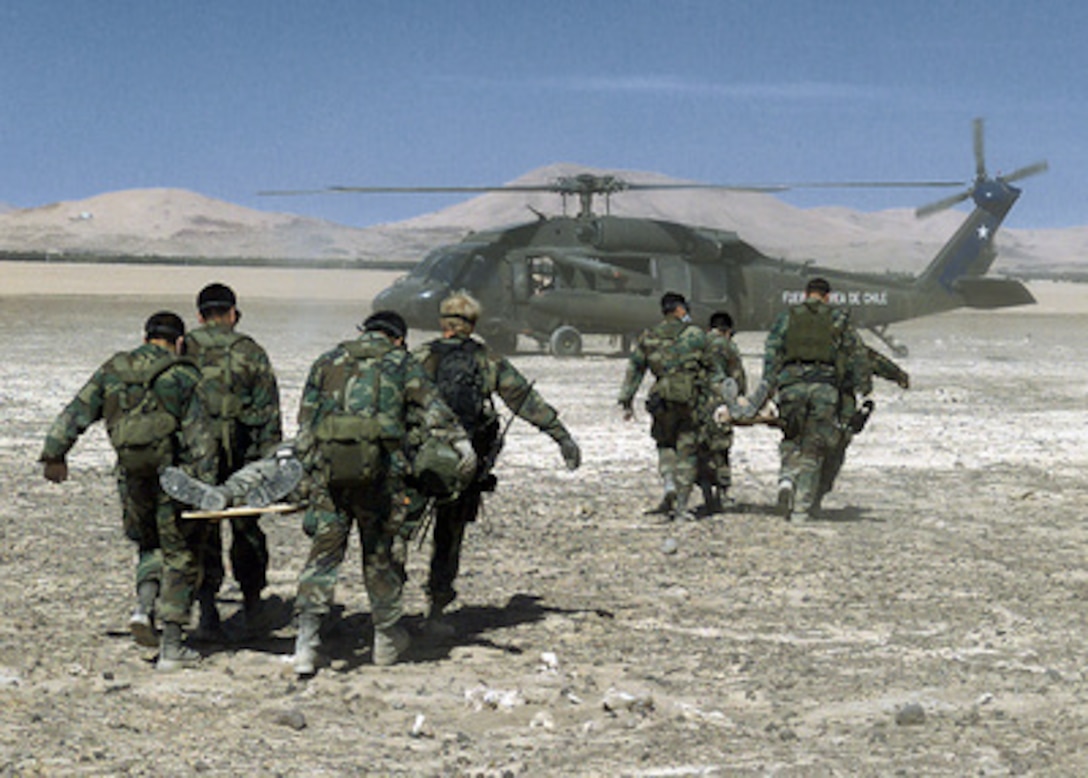 Pararescuemen from the California Air National Guard 129th Rescue Wing and members of the Chilean Air Force carry role-playing victims of a simulated crash to a Chilean Black Hawk helicopter for transport to a medical facility in the Atacama Desert north of Santiago, Chile, on Nov. 15, 2000. The mass casualty evacuation exercise was part of a medical and pre-trauma hospital response training exchange between the Chilean Air Force, California Air National Guard and the Wilford Hall Medical Center of Lackland Air Force Base, Texas. 