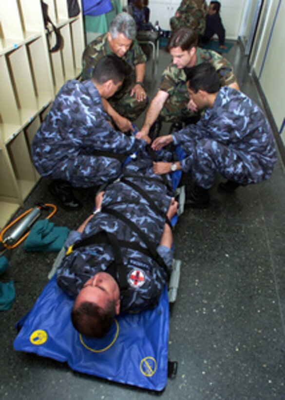 Members of Escuadrilla de Redespliegue Sanitario Aerotransportable Modular, the air evacuation unit of the Chilean Air Force, show Chief Master Sgt. Jose Tobo (upper left) and Tech. Sgt. Scott Drake (upper right) their application procedures of an air-splint during a pre-hospital trauma response course in Santiago, Chile, on Nov. 10, 2000. The course is part of medical and pre-trauma hospital response training exchange between the Chilean Air Force and the California Air National Guard. 