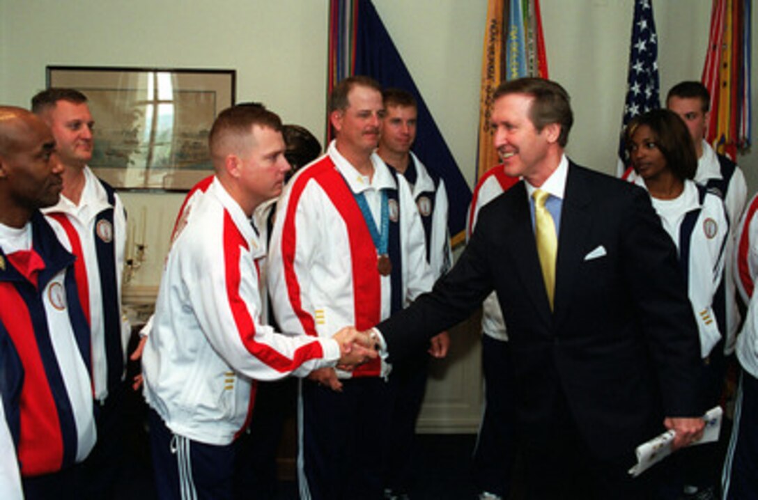 Secretary of Defense William S. Cohen congratulates military athletes who competed in the Summer 2000 Olympic Games held in Sydney, Australia, as they visit Cohen's office in the Pentagon on Nov. 28, 2000. The Olympians will take a special guided tour of the Pentagon following the meeting. 