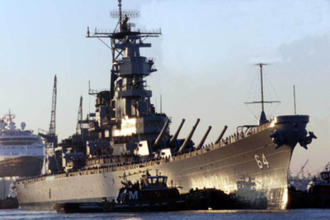 A tug boat nudges the bow of the battleship USS Wisconsin (BB 64) as the ship is pushed from the Norfolk Naval Shipyard to the Nauticus Museum in Norfolk, Va., on Dec. 7, 2000. The Wisconsin will be the centerpiece of a four-part exhibit on the battleship's role in Naval history. 
