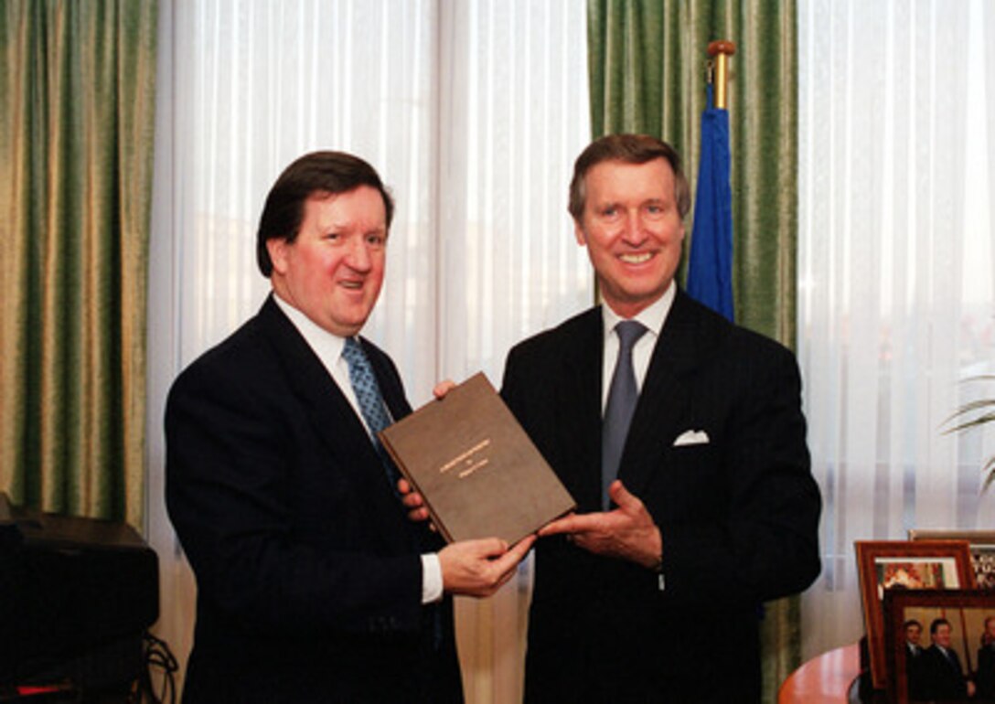 Secretary of Defense William S. Cohen (right) presents a book of his poetry to NATO Secretary General Lord George Roberts during their meeting at NATO Headquarters in Brussels, Belgium, on Dec. 5, 2000. This is Cohen's last scheduled trip to NATO Headquarters as defense secretary. 