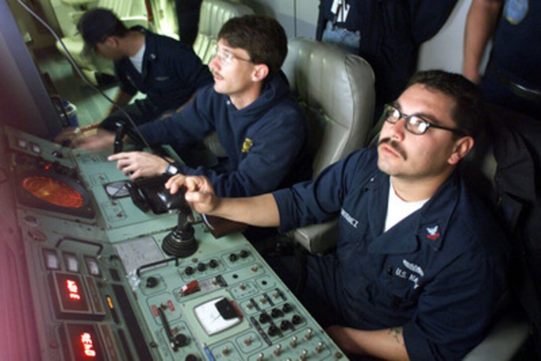Petty Officers 2nd Class Robert Rodriguez (right) and Robert Duncan (left) watch the video monitors as they search the ocean floor for the flight data recorder from the downed Alaska Airlines Flight 261 off the coast of Ventura County, Calif., on Feb. 3, 2000. Rodriguez is piloting the SCORPIO, a tethered unmanned work vehicle from the Navy's Deep Submergence Unit Unmanned Vehicle Detachment. Duncan is the co-pilot and is responsible for the robotic hands of the SCORPIO. The two Navy machinist's mates are controlling the submersible from the MV Kellie Chouest, a Military Sealift Command Submarine Support Ship. Rodriguez is from Amarillo, Texas, and Duncan is from Torrance, Calif. 