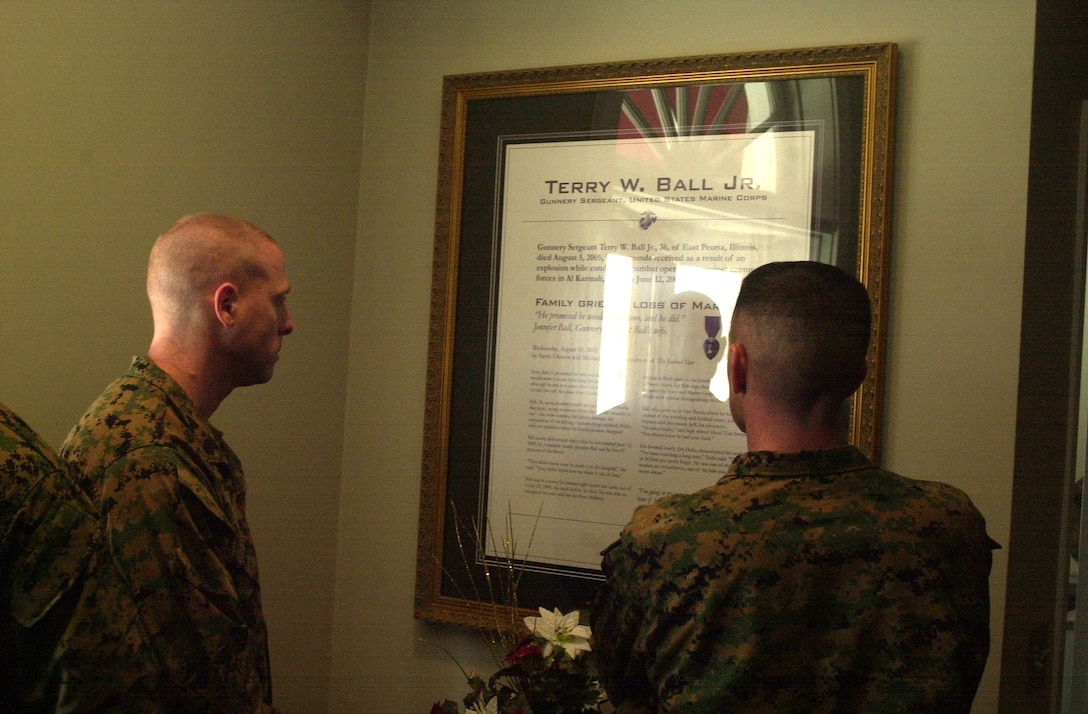 MARINE CORPS BASE CAMP LEJEUNE, N.C. - Two Marines who served with Gunnery Sgt. Terry W. Ball Jr. read about his career and different awards at the ribbon cutting of the multifunctional center named in his honor here Dec. 14. The recently renovated building was dedicated to Ball for his service to the Marine Corps during Operation Iraqi Freedom. Ball received fatal wounds from an explosion while conducting combat operations against enemy forces in Al Karmah, Iraq, while assigned to India Company, 3rd Battalion, 8th Marine Regiment, 2nd Marine Division. (Official U.S. Marine Corps photo by Lance Cpl. Brandon R. Holgersen)