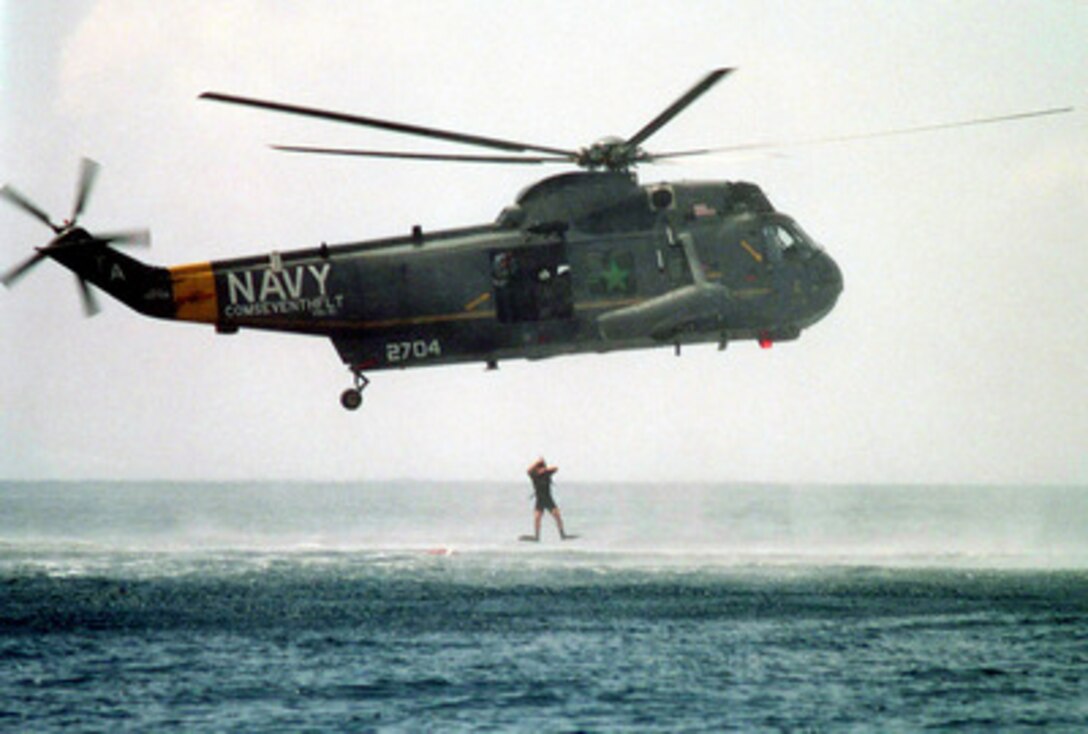Navy rescue swimmer Mark Podzon jumps from a SH-3H Sea King helicopter into the Flores Sea in Indonesia during a man overboard drill conducted by the USS Blue Ridge (LCC 19) on Feb. 14, 2000. Podzon is an Aviation Ordnanceman 3rd Class attached to Helicopter Anti-Submarine Light Squadron 51, deployed to the Blue Ridge from Naval Air Facility, Atsugi, Japan. The Blue Ridge is en route to the Persian Gulf where it will join Operation Southern Watch. 