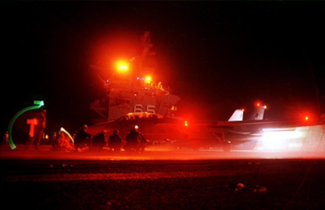 A U.S. Navy F-14A Tomcat goes into full afterburner as it prepares to catapult from the flight deck of USS Enterprise (CVN 65) during night flight operations on Feb. 14, 2000, in the Atlantic Ocean. Red lights are used to illuminate the flight deck because the red light won't interfere with the night vision of the air crews and the flight deck crew. The Tomcat is attached to Fighter Squadron 41 of Naval Air Station Oceana, Va. The aircraft carrier is conducting carrier qualifications in the Atlantic. 