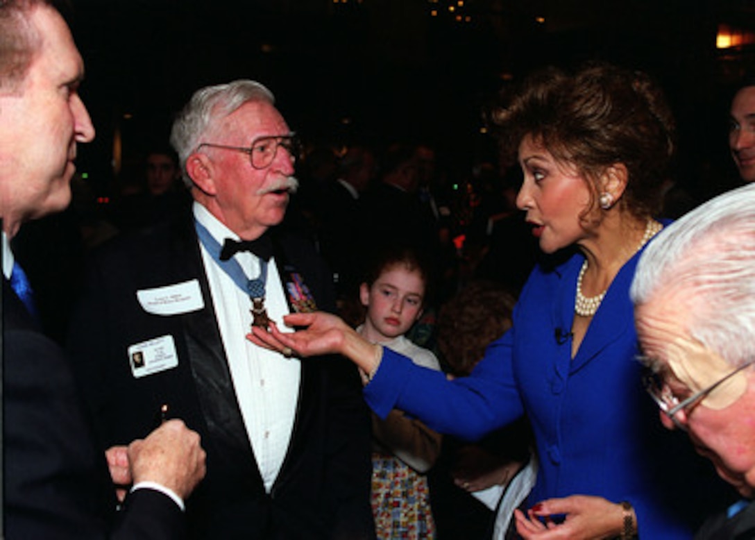 Janet Langhart Cohen (right) and Secretary of Defense William S. Cohen (left) talk with retired Col. Lewis Millett, U.S. Army, at a pre-concert reception for Medal of Honor recipients in Washington, D.C., on Feb. 21, 2000. Cohen and his wife are hosting the Pentagon Pops, a musical salute with the theme of The Hero of the Century--the American G.I., at the Daughters of the American Revolution Constitution Hall. Millett earned his medal while serving with the 27th Infantry Regiment during WW II. 