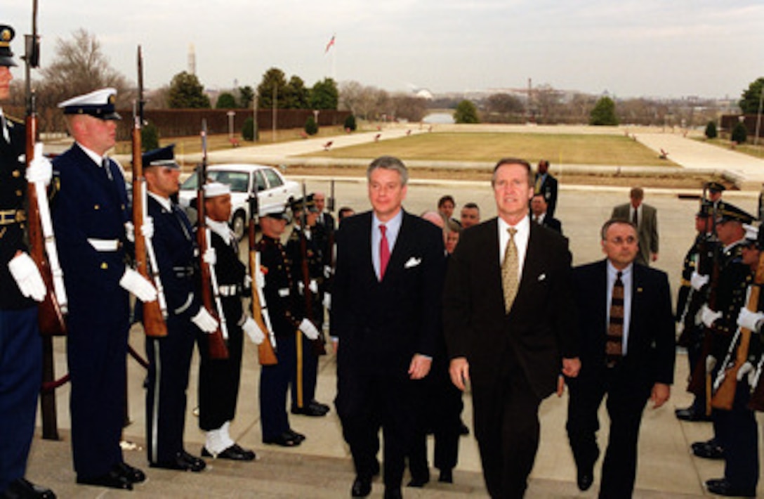 French Minister of Defense Alain Richard (left) is escorted by Secretary of Defense William S. Cohen (right) through an armed forces honor cordon into the Pentagon on Feb. 23, 2000. 