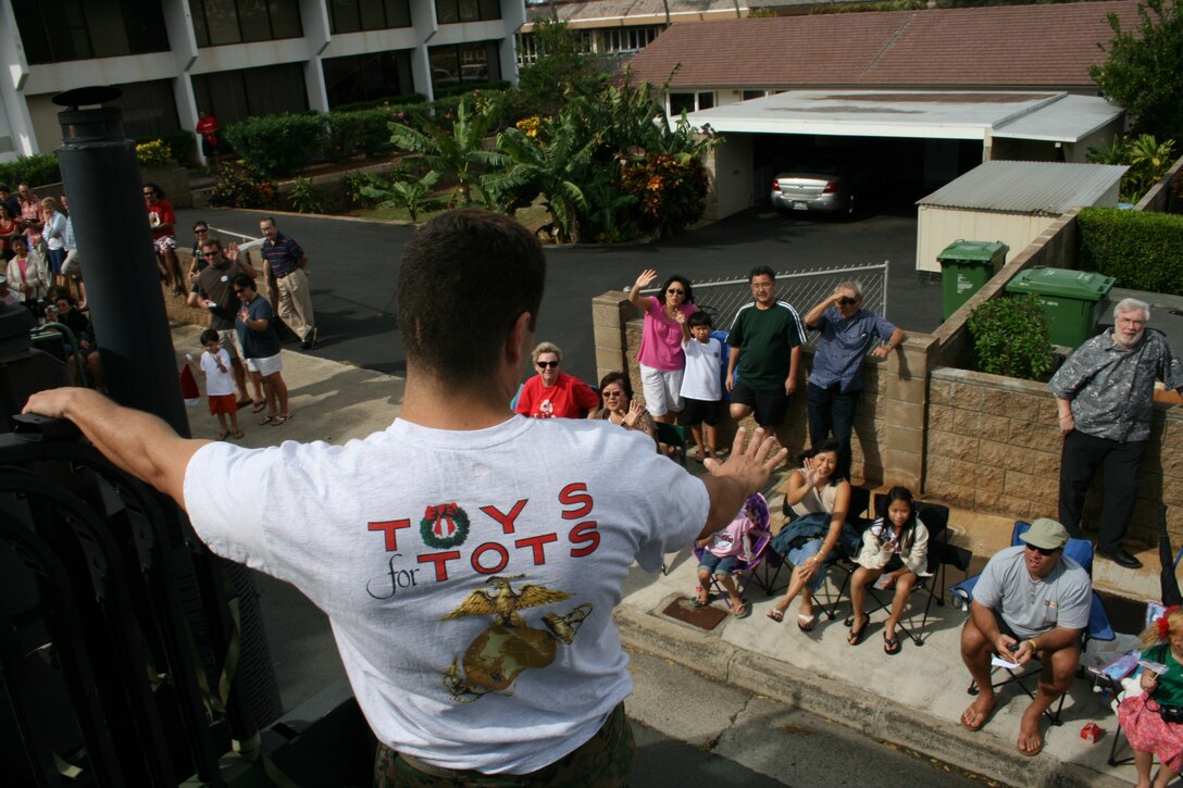 HONOLULU- Sgt Jose Godinez of 4th Force Reconnaissance Company waves to the crowd during the Hawaii Kai Christmas Parade Nov. 29.  The Marines collected toys to support the Toys for Tots campaign.  All toys collected here will go to less-fortunate children in Hawaii.