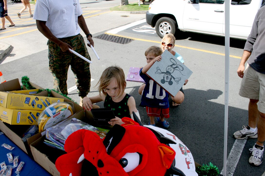 HONOLULU- Rylee Berger, 6 and her brother Jake, 4, place toys in drop boxes at the Koko Marina Shopping Center Nov. 29.  The Marines collected toys during the Hawaii Kai Christmas Parade and set up a booth at the shopping center.