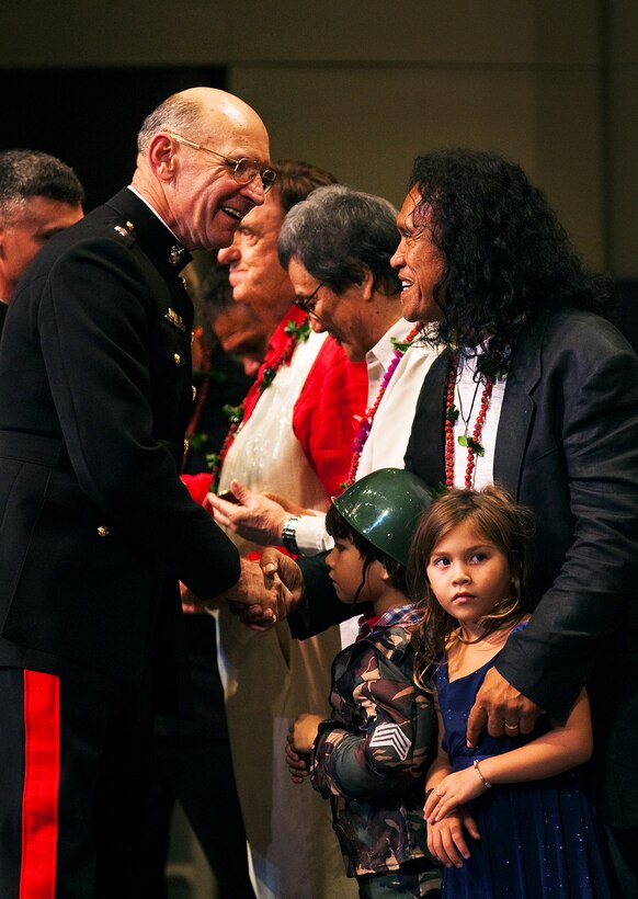 Lt. Gen. Duane D. Thiessen, Commander, U.S. Marine Corps Forces, Pacific, presents Henry Kapono, professional musician, singer and songwriter, his personal challenge coin after the Fourth Annual Na Mele o na Keiki (Music for the Children) Concert at the Neal S. Blaisdell Concert Hall on Dec. 1. Thiessen gave a coin to each of the local performers after the concert. The concert was an opportunity for the community to make donations to the Marine Corps Reserve’s Toys for Tots Hawaii Program.