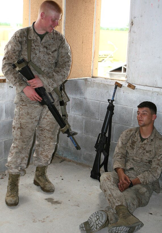 Lance Cpls. Jeffrey S. Webb (right) and Ryan T. Tillotson, with 6th Platoon, 1st Fleet Anti-terrorism Security Team Company, relax during a brief break from training at the Military Operations in Urban Terrain facility here Sept. 13.  The Marines went through a seven-day unit training. The Camp Allen, Va.-based unit conducted a seven-day unit training that focused on learning and implementing urban combat tactics and techniques.