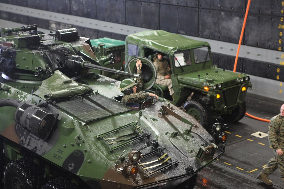 Marines from Special Purpose Marine Air Ground Task Force 26 direct vehicles from a Landing Craft Air Cushioned onto USS New York off the coast of Marine Corps Base Camp Lejeune, N.C., Oct. 30, 2009. Marines from several units merged to form SPMAGTF-26 for the ship's commissioning in New York City, Nov. 7.