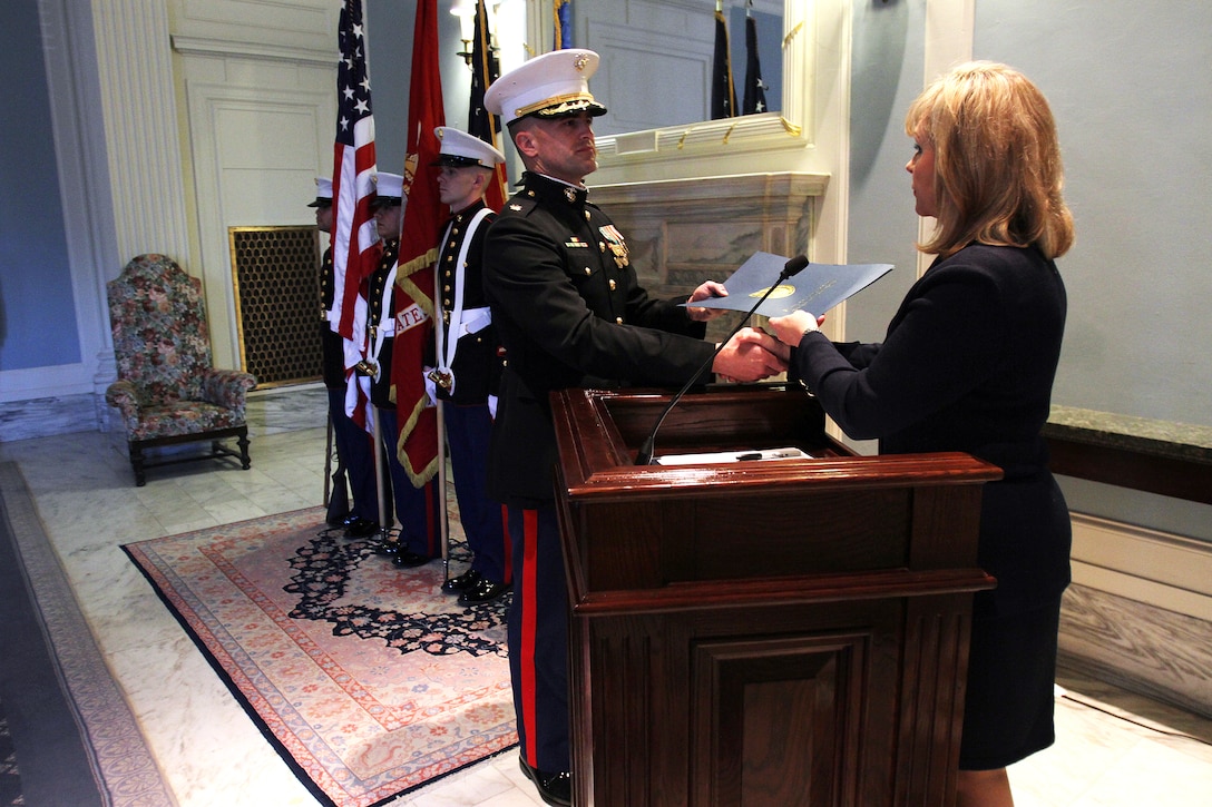 Gov. Mary Fallin, the governor of Oklahoma, hands the document proclaiming November as "Marine Month" in the state of Oklahoma, to Maj. Richard Robinson, III, commanding officer of Marine Corps Recruiting Station Oklahoma City. After officially issuing the proclamation, Fallin participated in a traditional birthday cake cutting ceremony as the guest of honor, to commemorate the event at the state capitol here, Nov. 9.