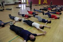 Marine Corps recruiters from the Roseville, Minn., substation supervise poolees and newly-pinned Marines while they perform exercises during a Delayed Entry Program function at the University of Minnesota Armory Dec. 18. The main focus of the event centered on turning mush into muscle; however, Marines also stressed the importance of camaraderie and unit cohesion once they become one of the few and the proud.
