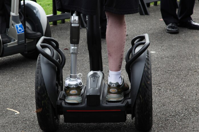 A wounded warrior rides the Segway across the stage to demonstrate the usefulness of the Segway at the Segs4Vets presentation in front of the Marine Corps War Memorial in Arlington Va., Oct. 6, 2010. Recipients of the Segways included members of the Marine Corps, Army and the Army National Guard. Before the wounded warriors receive their Segways they are required to take a training course so that they learn to use the device safely and properly.