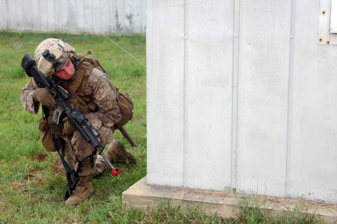 A Marine with B Company, Battalion Landing Team 1st Battalion, 9th Marine Regiment, 24th Marine Expeditionary Unit,  peeks around a corner while holding a security position during his unit's raid of Camp Cooke at U.S. Army Base A.P. Hill, Va.  The company honed its skills during this practice run before undergoing certification testing later in the month.  (U.S. Marine Corps Photo by LCpl. David J. Beall)
