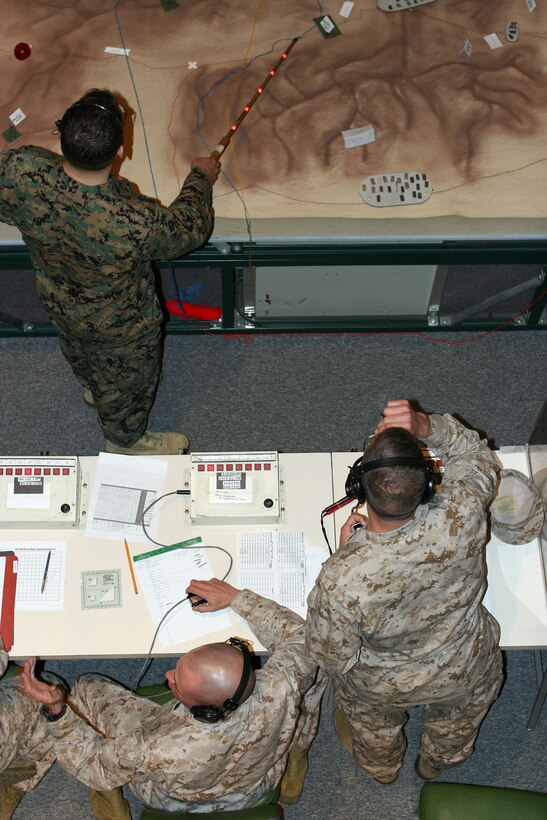 MARINE CORPS BASE CAMP LEJEUNE, N.C. - Trainees from the staff non-commissioned officer academy (pictured in desert camouflage uniforms) plan their attack as an instructor prepares to move a combat unit on the terrain board April 7. The CAST, part of the modeling and simulation section, II Marine Expeditionary Force, gives Marines the opportunity to practice call for fire and maneuver in a simulated, role-playing environment.  (Official U.S. Marine Corps photo by Cpl. Ruben D. Maestre)