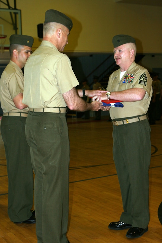 MARINE CORPS BASE CAMP LEJEUNE, N.C. - Master Gunnery Sgt. Paul R. Parker Jr., receives from Brig. Gen. Mastin M. Robeson, commanding general, 4th Marine Expeditionary Brigade, a letter of commendation from President George W. Bush and flag which flew over the U.S. Marine Corps Memorial in Arlington, Va., during a retirement ceremony held in his honor April 8.  Parker, a native of Louisville, Ky., retired after nearly 27 years of service that included deployments to the Middle East and Japan.  He is the son of Paul Parker Sr., of Morgantown, Ky.  (Official U.S. Marine Corps photo by Cpl. Ruben D. Maestre)
