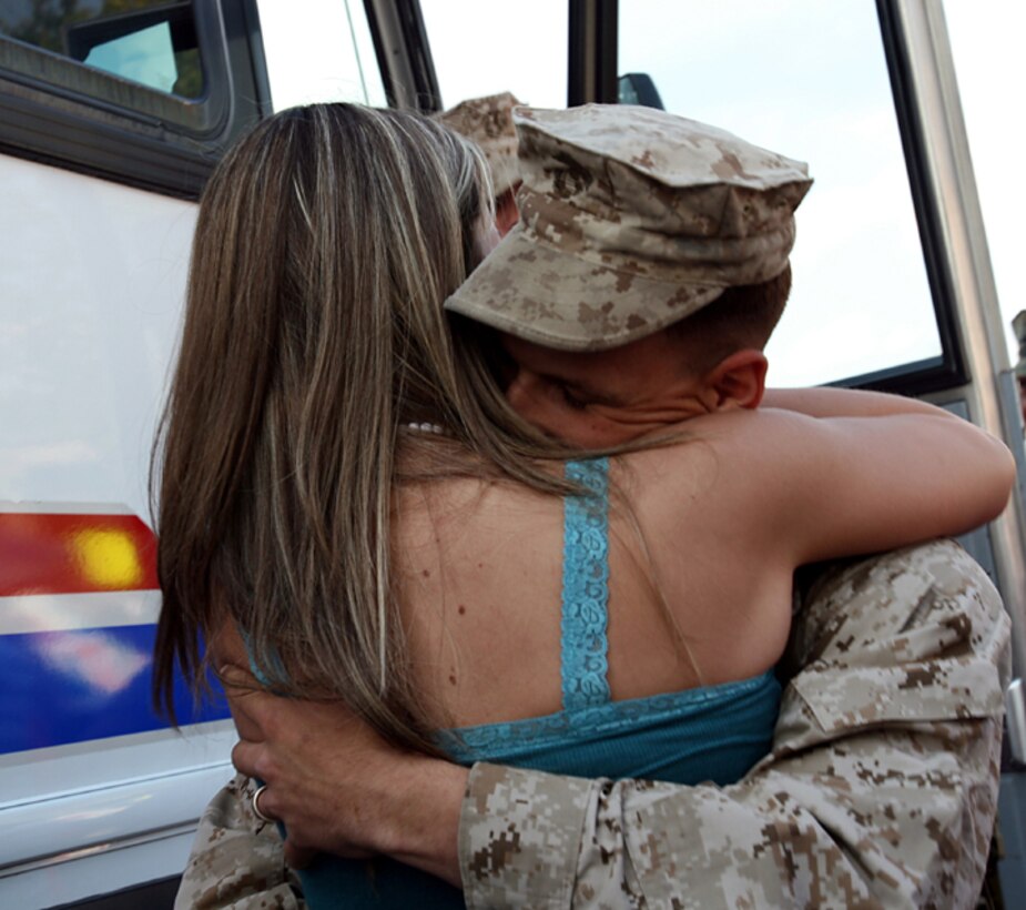A Marine with 1st Battalion, 6th Marine Regiment, 2nd Marine Division, gives his loved one a tight embrace as he steps off the bus. Family members rushed the bus to embrace their Marines and sailors after the nine month deployment to Ramadi Iraq in support of Operation Iraqi Freedom.