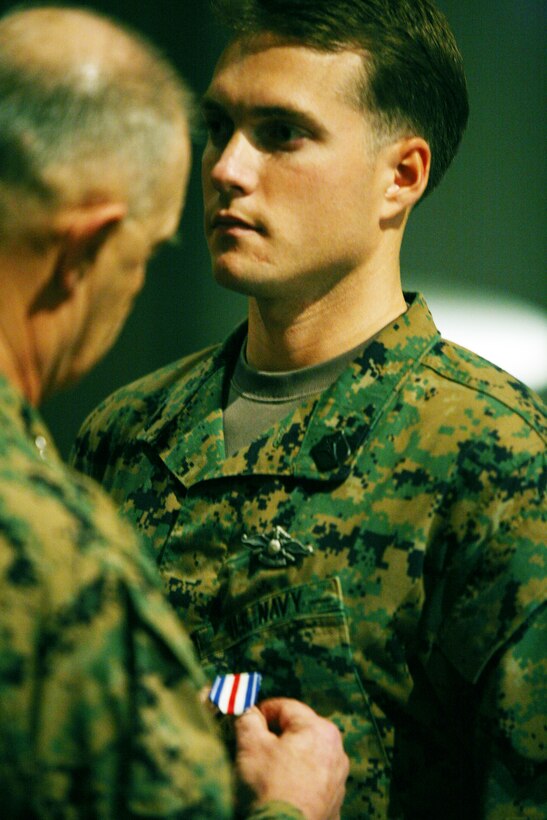 Lt. Gen. Dennis J. Hejlik, commander of the II Marine Expeditionary Force, pins the Silver Star Medal on Petty Officer 2nd Class Joshua Simson, a hospitalman with 5th Battalion, 10th Marine Regiment, 2nd Marine Division, here Feb. 26. Simson was awarded the medal for heroic actions during an ambush while he was working as an advisor in Afghanistan with Embedded Training Team 6-2.