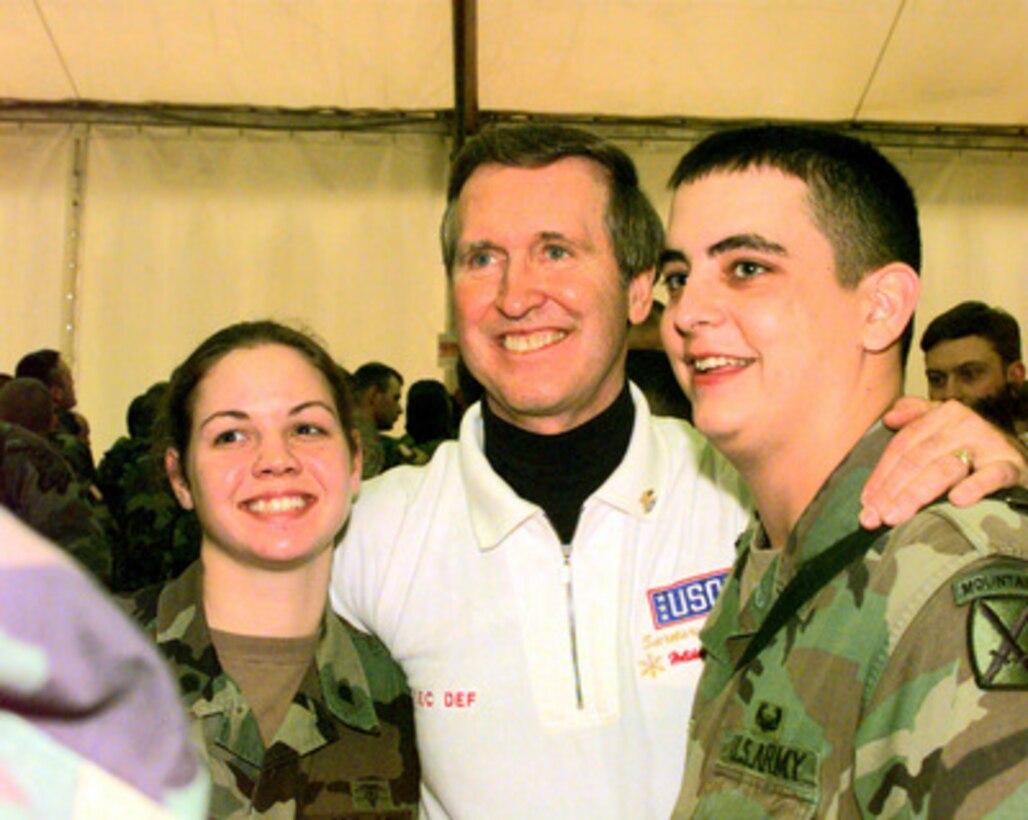 Secretary of Defense William S. Cohen poses for a photograph with soldiers from the 10th Mountain Division during a United Service Organizations (USO) show in the Eagle Sports Complex at Tuzla Air Base, Bosnia and Herzegovina, on Dec. 22, 1999. The soldiers are deployed on a peacekeeping mission in Bosnia and Herzegovina in support of Operation Joint Forge. 