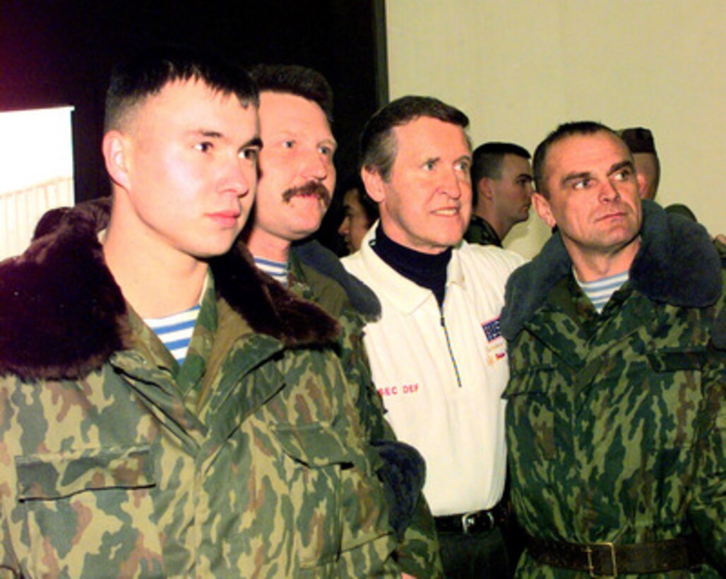Secretary of Defense William S. Cohen poses for a photograph with Russian soldiers during a United Service Organizations (USO) show in the Eagle Sports Complex at Tuzla Air Base, Bosnia and Herzegovina, on Dec. 22, 1999. The Russians along with U.S. soldiers are components of Multinational Division North and are deployed on a peacekeeping mission in Bosnia and Herzegovina in support of Operation Joint Forge. 