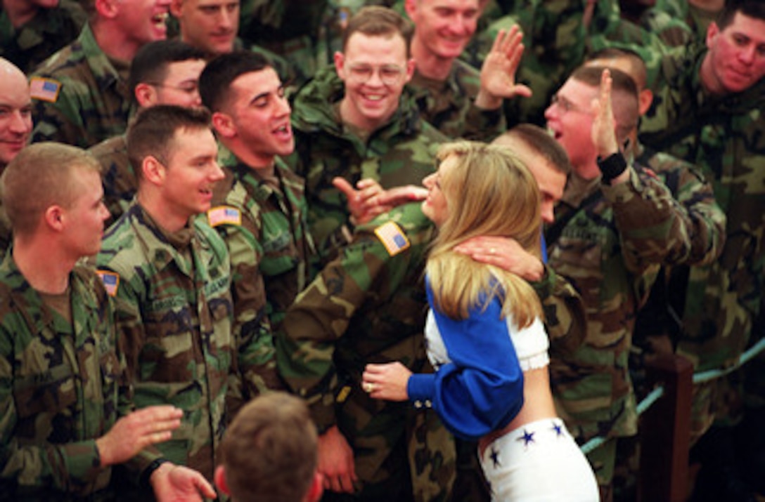 While others celebrate, some U.S. Army soldiers are giddy with anticipation as they wait to meet a member of the Dallas Cowboys Cheerleaders after a United Service Organizations (USO) show in the Eagle Sports Complex at Tuzla Air Base, Bosnia and Herzegovina, on Dec. 22, 1999. The Cheerleaders are part of Secretary of Defense William S. Cohen's third annual holiday tour and USO show. 