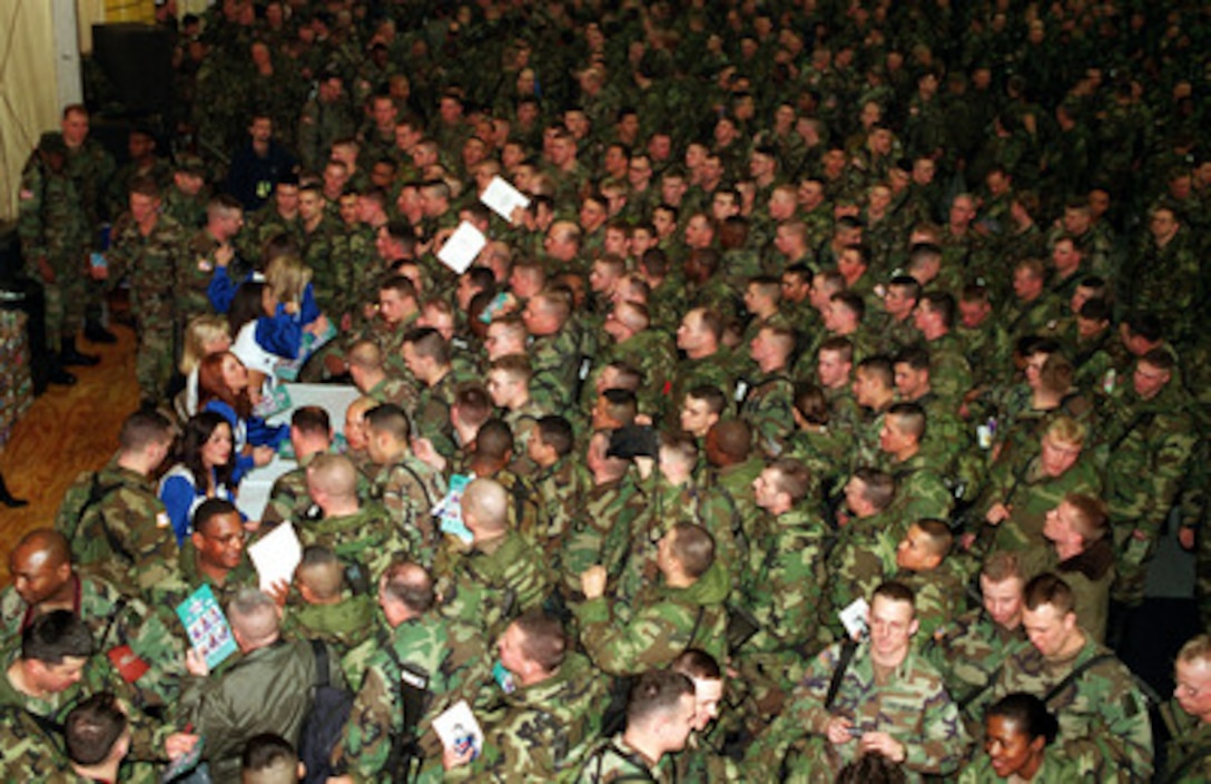 Members of the Dallas Cowboys Cheerleaders are swamped with soldiers seeking autographs during a United Service Organizations (USO) show in the Eagle Sports Complex at Tuzla Air Base, Bosnia and Herzegovina, on Dec. 22, 1999. The Cheerleaders are part of Secretary of Defense William S. Cohen's third annual holiday tour and USO show. 