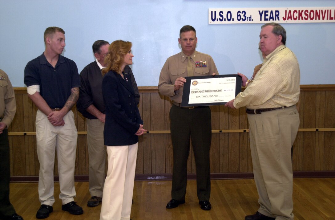 MARINE CORPS BASE CAMP LEJEUNE, N.C. - Al Barnes (right), a representative for the Swansboro Rotary Club presents a check for $6,000 to Col. William Meiers, chief of staff, Marine Corps Base, to go toward the Wounded Warrior Fund. The check is for service members wounded in battle, to provide financial help for clothing and items they may need during their time of recovery. Also in the photo from left to right include Lance Cpl. Michael Meyer, a Marine wounded during Operation Iraqi Freedom, Hunter Hadley, a representative for Swansboro Rotary Club, Judy Pitchford, executive director, Jacksonville United Services Organization. (Official Marine Corps photo by Lance Cpl. Christopher S. Vega)