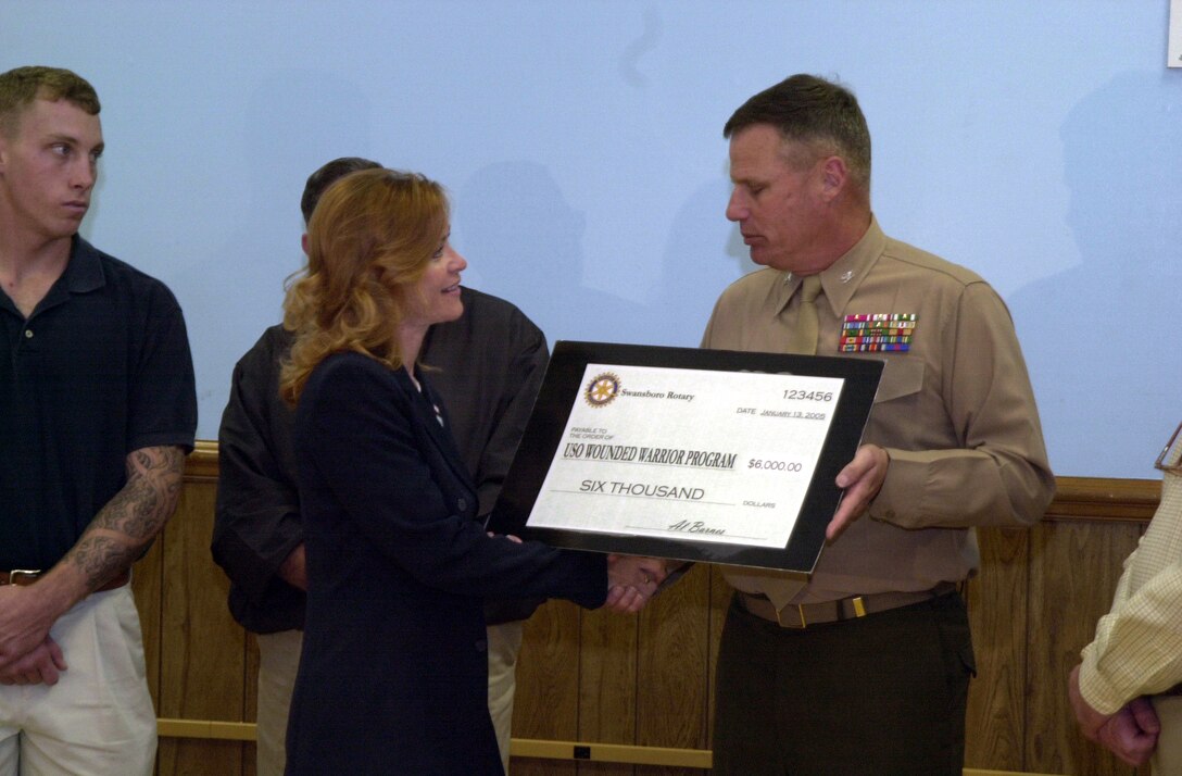 MARINE CORPS BASE CAMP LEJEUNE, N.C. - Colonel William Meiers, chief of staff, Marine Corps Base, presents a check given by the Swansboro Rotary Club to Judy Pitchford, executive director, Jacksonville United Services Organization, to go toward the Wounded Warrior Fund. According to Pitchford, the fund originated two years ago, at the start of the deployments. The intent of the fund is to provide help and comfort to Marines injured during a deployment. (Official Marine Corps photo by Lance Cpl. Christopher S. Vega)