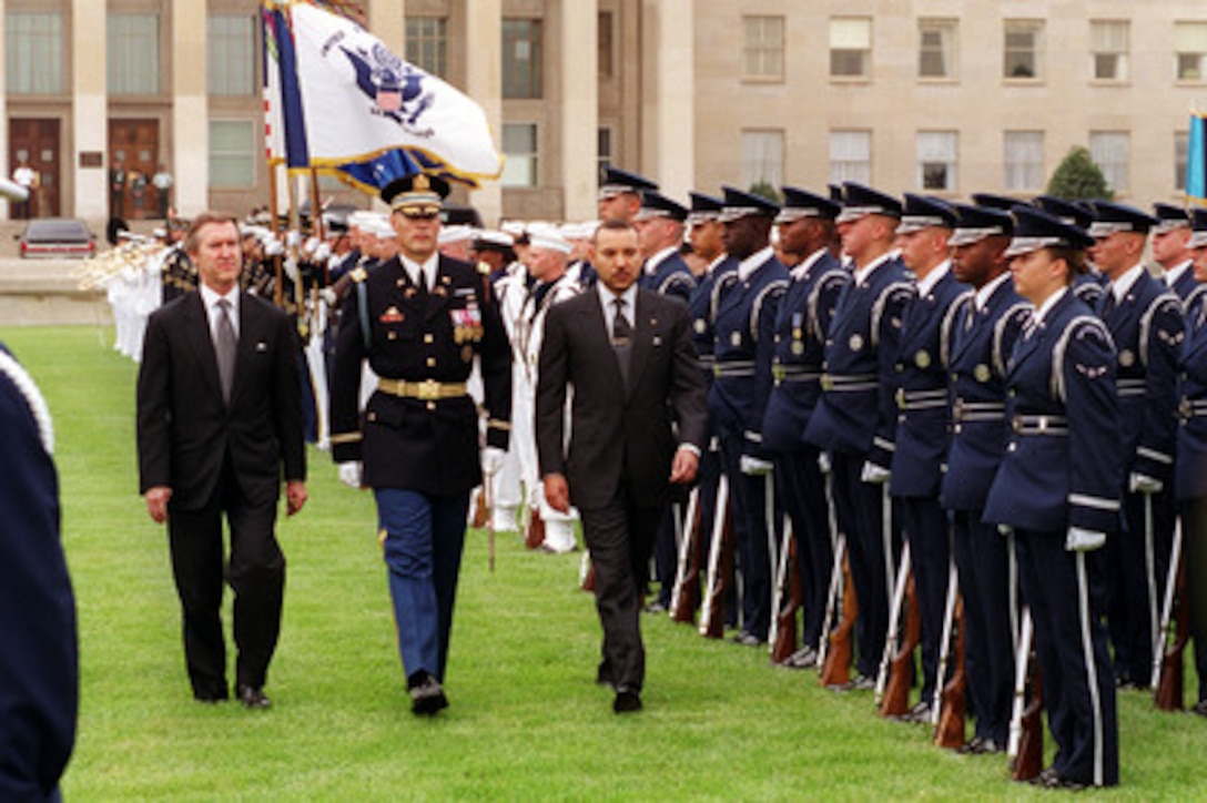 His Majesty King Mohamed VI of Morocco (right) inspects the joint service honor guard at the Pentagon during a full honor arrival ceremony hosted by Secretary of Defense William S. Cohen (left) on June 21, 2000. Escorting the two dignitaries is Col. Thomas M. Jordan, U.S. Army, commander of the 3rd U.S. Infantry (The Old Guard). 