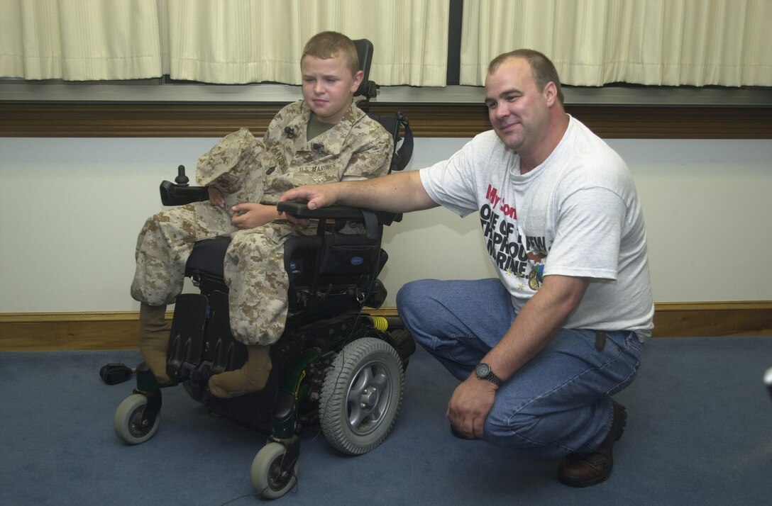 MARINE CORPS BASE CAMP LEJEUNE, N.C. - Hunter Box (left) sits with is father Fritz P. Box after being awarded the title of Honorary Marine here June 29. Box, 11, from Dunlap, Tenn., joined the ranks of the few and the proud June 29 after being bestowed the title of Honorary Marine by Maj. Gen. Robert Dickerson, the Marine Corps Base commanding general at building one. (Official U.S. Marine Corps photo by Lance Cpl. Brandon R. Holgersen)