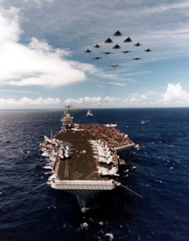 Aircraft from Carrier Air Wing 9 fly over the aircraft carrier USS John C. Stennis (CVN 74) in a delta formation as the ship steams for its home port of San Diego, Calif., on June 29, 2000. The Stennis is hosting nearly one thousand friends and family members, called Tigers, for the transit from Pearl Harbor, Hawaii, to San Diego. This Tiger Cruise allows the friends and family members to experience life at sea with their sailors. 