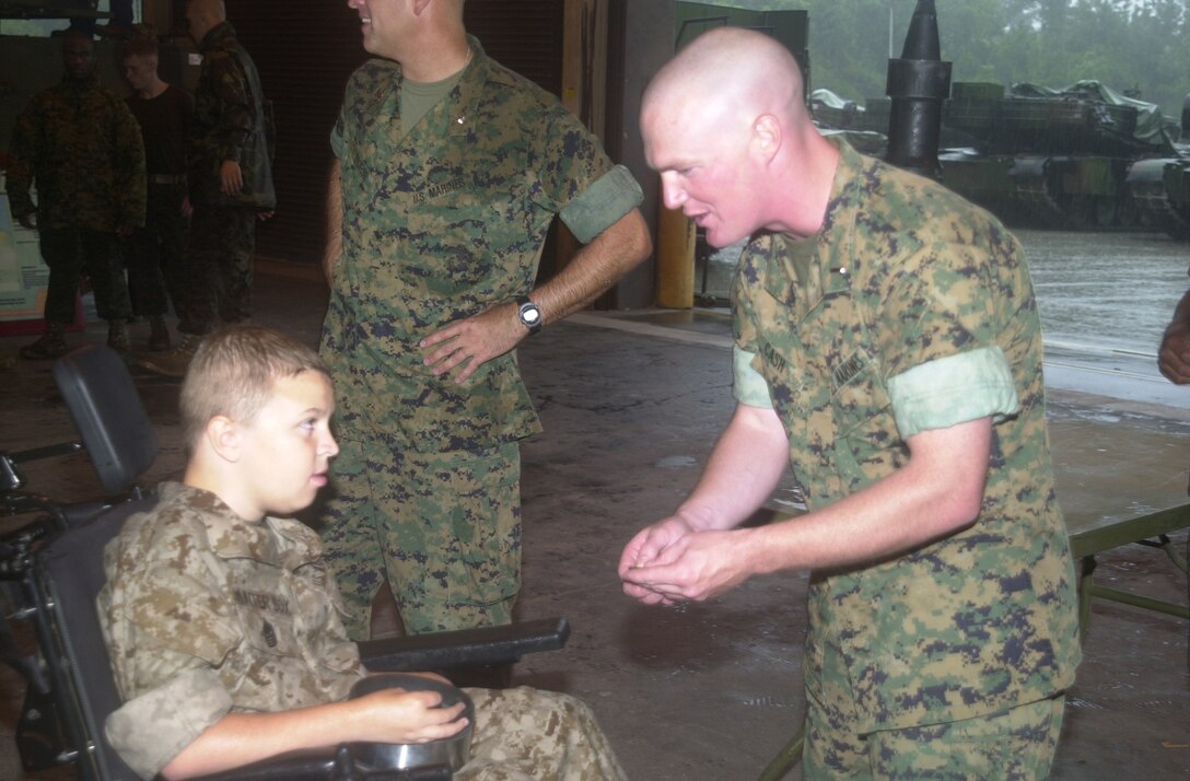 MARINE CORPS BASE CAMP LEJEUNE, N.C. - 1st Lt. Joe Cash (left), the commander for Company C, 2d Tank Battalion, 2d Marine Division gives Hunter Box a unit coin here June 29. Box, 11, from Dunlap, Tenn., joined the ranks of the few and the proud June 29 after being bestowed the title of Honorary Marine by Maj. Gen. Robert Dickerson, the Marine Corps Base commanding general at building one. (Official U.S. Marine Corps photo by Lance Cpl. Brandon R. Holgersen)