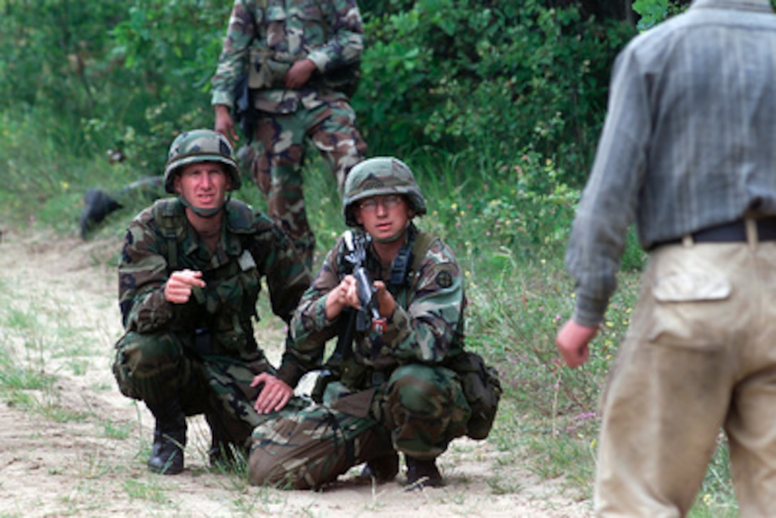 Sgt. Zachary Sarver (center) and Spc. Gary Vandenbos (left) negotiate with a role-playing inebriated woodsman whose land their patrol passed through during a field training portion of Exercise Peaceshield 2000 in Yavoriv, Ukraine, on July 16, 2000. Approximately 1000 soldiers from 22 countries are taking part in the peacekeeping training exercise at the Partnership for Peace Training Center at Yavoriv. Sarver and Vandenbos are attached to Bravo Company, 2nd Battalion, 130th Infantry, Illinois Army National Guard. 