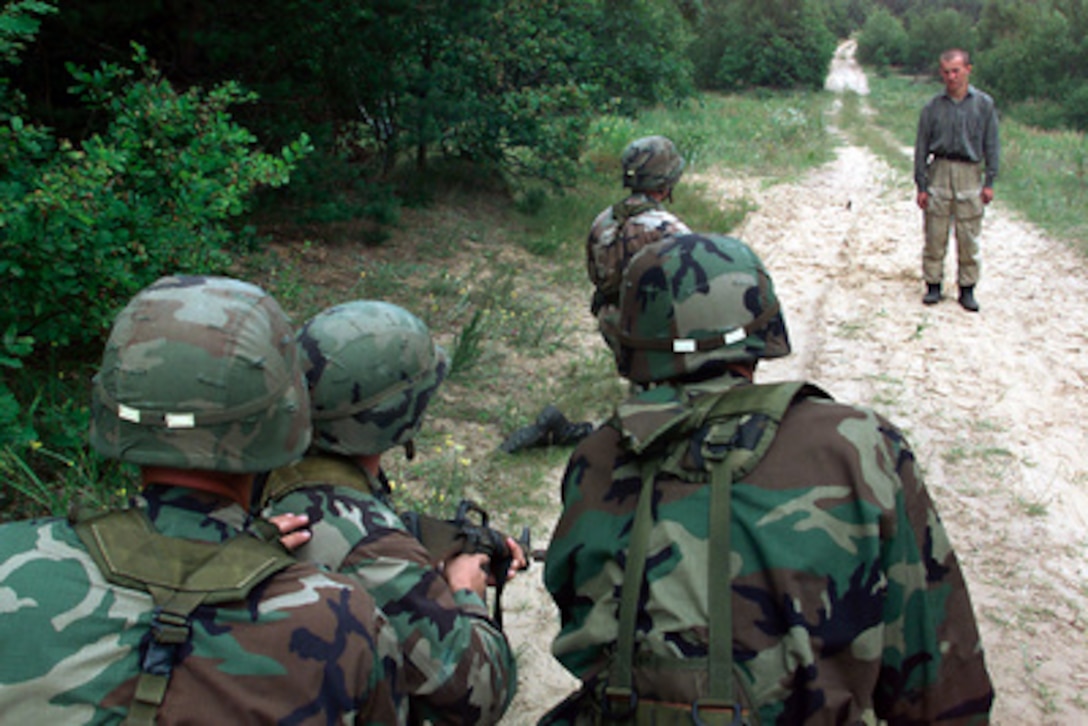 Soldiers from Bravo Company, 2nd Battalion, 130th Infantry, Illinois Army National Guard negotiate with a role-playing inebriated woodsman whose land their patrol passed through during a field training portion of Exercise Peaceshield 2000 in Yavoriv, Ukraine, on July 16, 2000. Approximately 1000 soldiers from 22 countries are taking part in the peacekeeping training exercise at the Partnership for Peace Training Center at Yavoriv. 