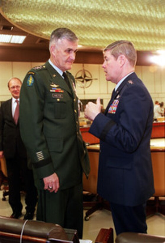 Supreme Allied Commander Europe Gen. Joseph W. Ralston (right), U.S. Air Force, and Chairman of the Joint Chiefs of Staff Gen. Henry H. Shelton (left), U.S. Army, discuss an issue before the start of the North Atlantic Council (Defense) meeting at NATO Headquarters in Brussels, Belgium, on June 8, 2000. 