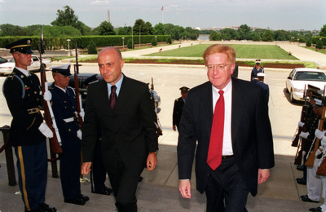 Italian Under Secretary of State Marco Minniti (left) is escorted by Deputy Secretary of Defense Rudy de Leon (right) through an honor cordon as he arrives at the Pentagon on July 12, 2000. 