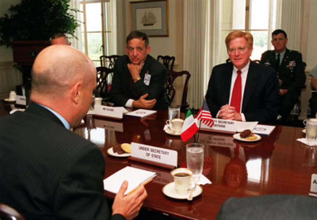 Deputy Secretary of Defense Rudy de Leon (right) hosts a meeting with Italian Under Secretary of State Marco Minniti (foreground) at the Pentagon on July 12, 2000. The two men are meeting to discuss military acquisition issues. Principal Deputy Under Secretary of Defense for Acquisition and Technology David Oliver (center) joined the discussion on military acquisition issues. 