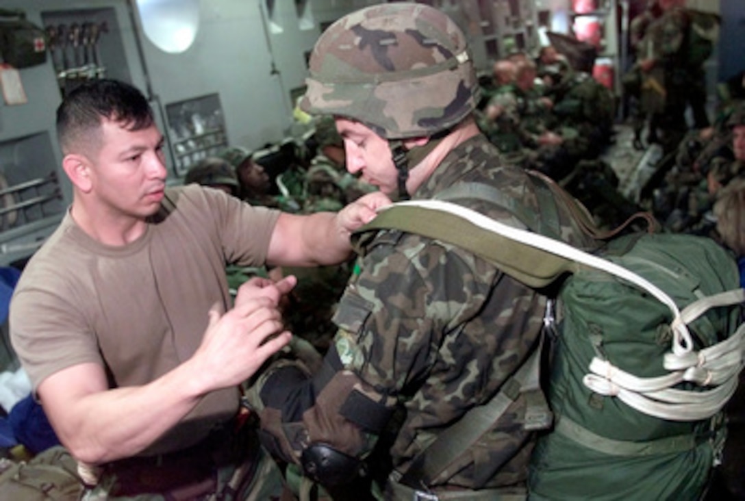 U.S. Army 82nd Airborne Staff Sgt. Mario Cuevas (left) checks the gear of Ukrainian paratrooper Lt. Col. Senchik Volodimiz onboard a C-17 Globemaster III as they near the Sokol drop zone at Yavoriv, Ukraine, on July 17, 2000. An international mix of 172 paratroopers are flying directly from Fort Bragg to Yavoriv, Ukraine, and jumping in support of Exercise Peaceshield 2000. Approximately 1000 soldiers from 22 countries are taking part in the peacekeeping training exercise at the Partnership for Peace Training Center at Yavoriv. 